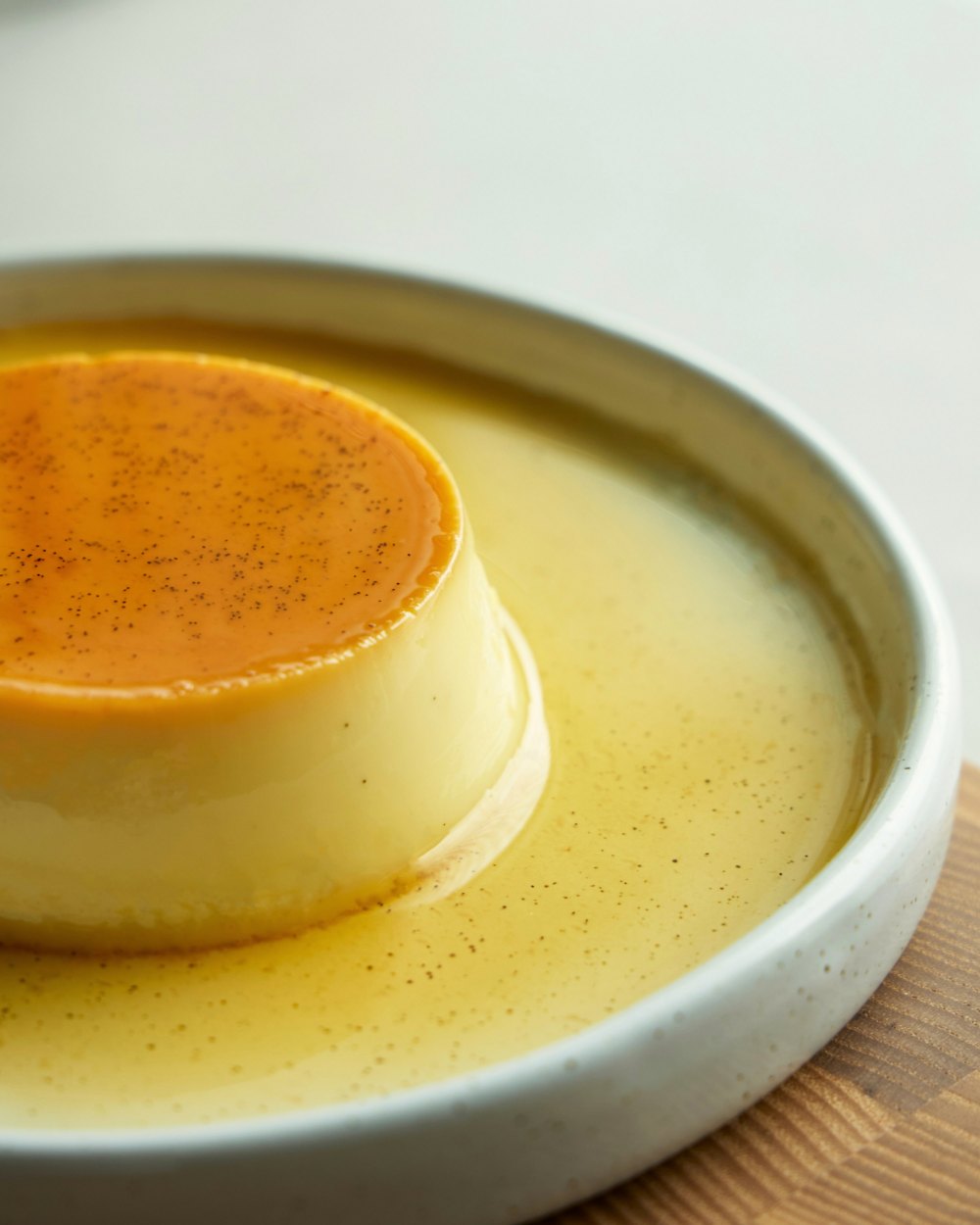 Flan casero con caramelo en un plato blanco