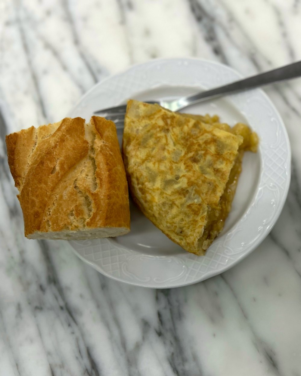 Pintxo de tortilla de patata con pan sobre una barra de mármol
